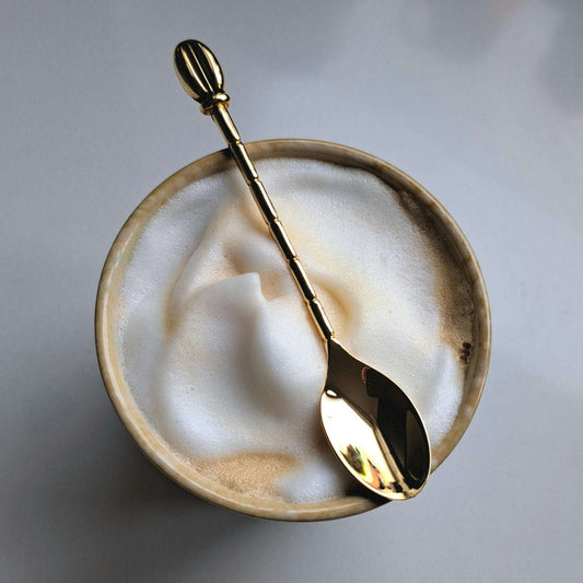 Koffielepel goudkleurig met detail van koffieboontje en structuur op de steel