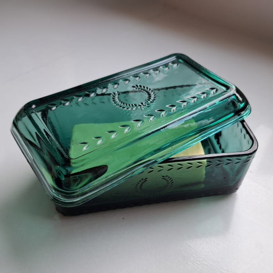 Sfeerbeeld van glazen gekleurde botervloot met boter er in.