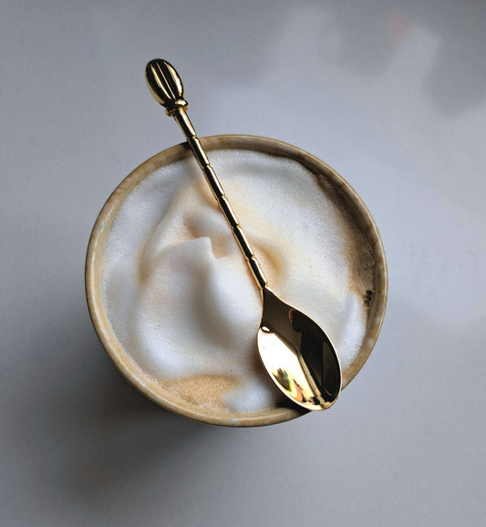 Koffielepel goudkleurig met detail van koffieboontje en structuur op de steel